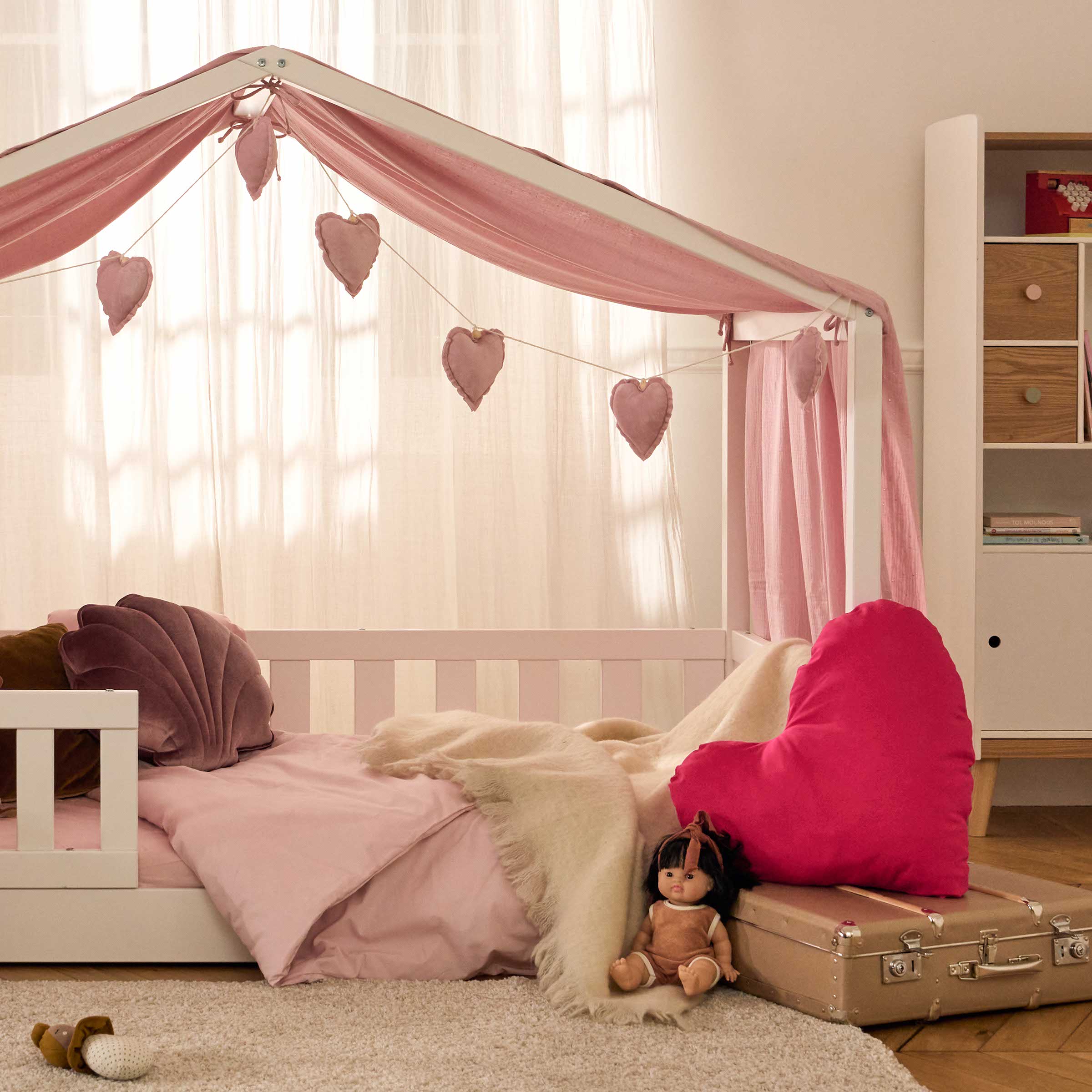 Lit enfant cabane Paris Story en bois clair, avec barrières, matelas et linge de lit beige.