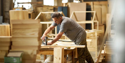 Handcrafted wooden cabin bed factory, with machines, workers and visible materials for an eco-friendly children's bed.