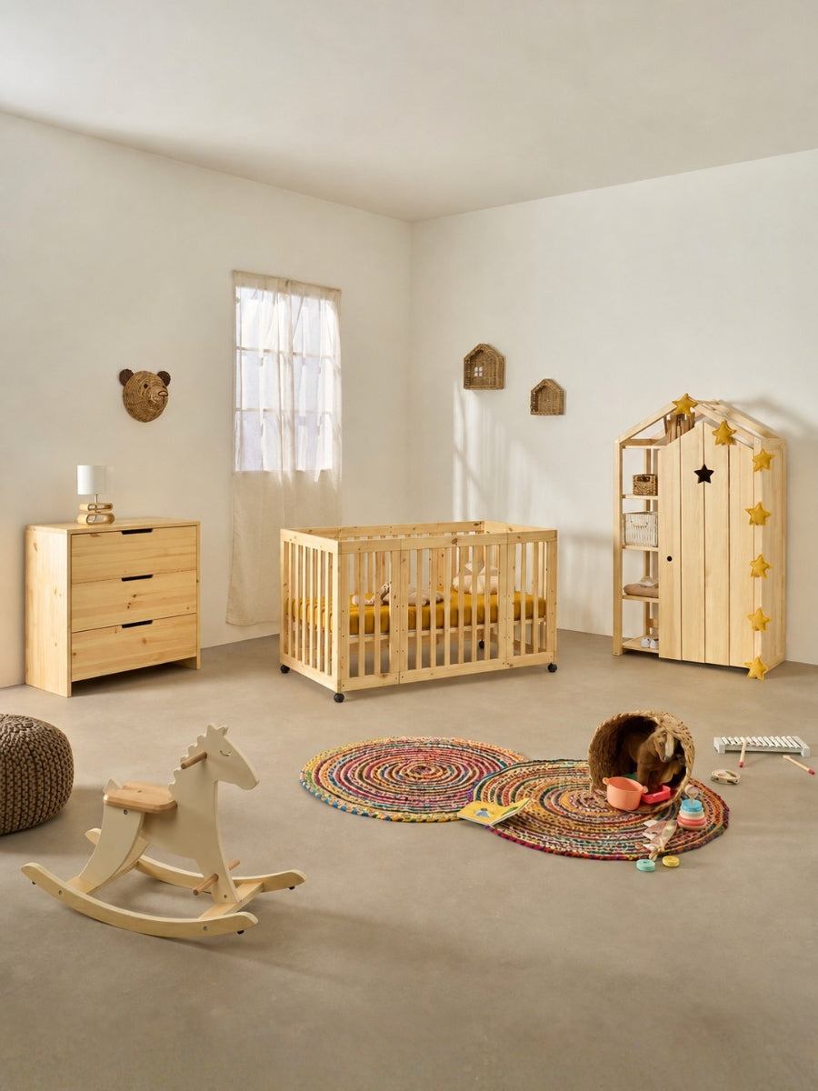 Berceau bébé Kokomo 7-en-1 en bois naturel, installé dans une chambre douce et lumineuse, avec roulettes pour le déplacer facilement et un design évolutif pensé pour accompagner les premières années de bébé.