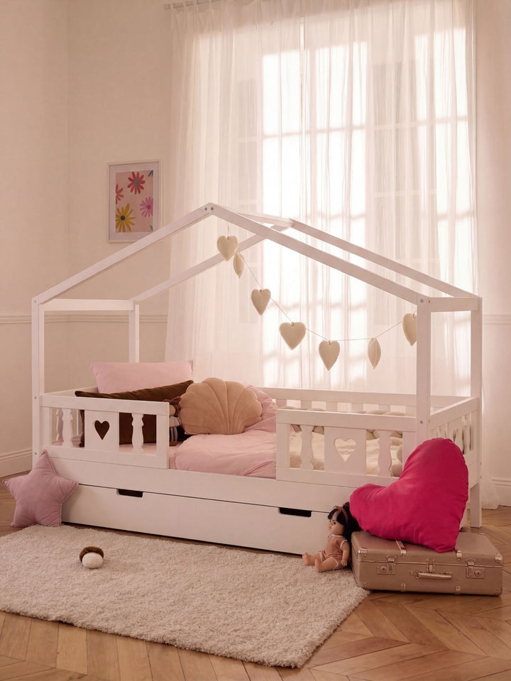 Lit bébé Paris blanc, design cœur, barrières sécurisées, ambiance chambre enfant moderne.