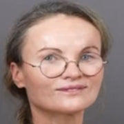 Portrait professionnel souriant de Delphine, élégante femme d'affaires en chemisier bleu.