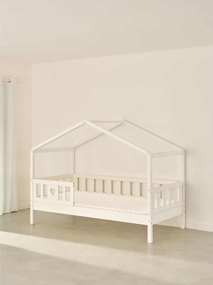 Lit cabane enfant blanc Paris Cabania avec barrière cœur, design scandinave bois pour chambre bébé et enfant.