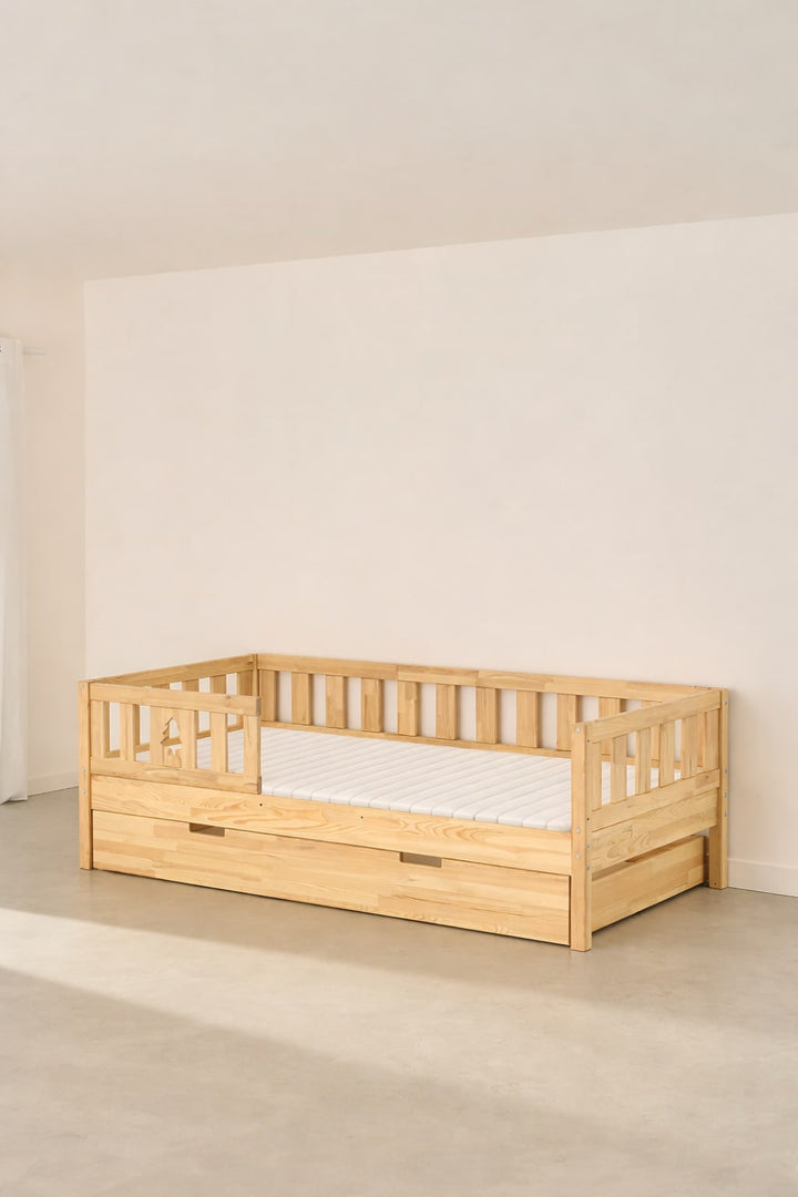 Lit évolutif enfant Barcelone naturel en sapin massif avec barrières de sécurité et un tiroir de rangement intégré.