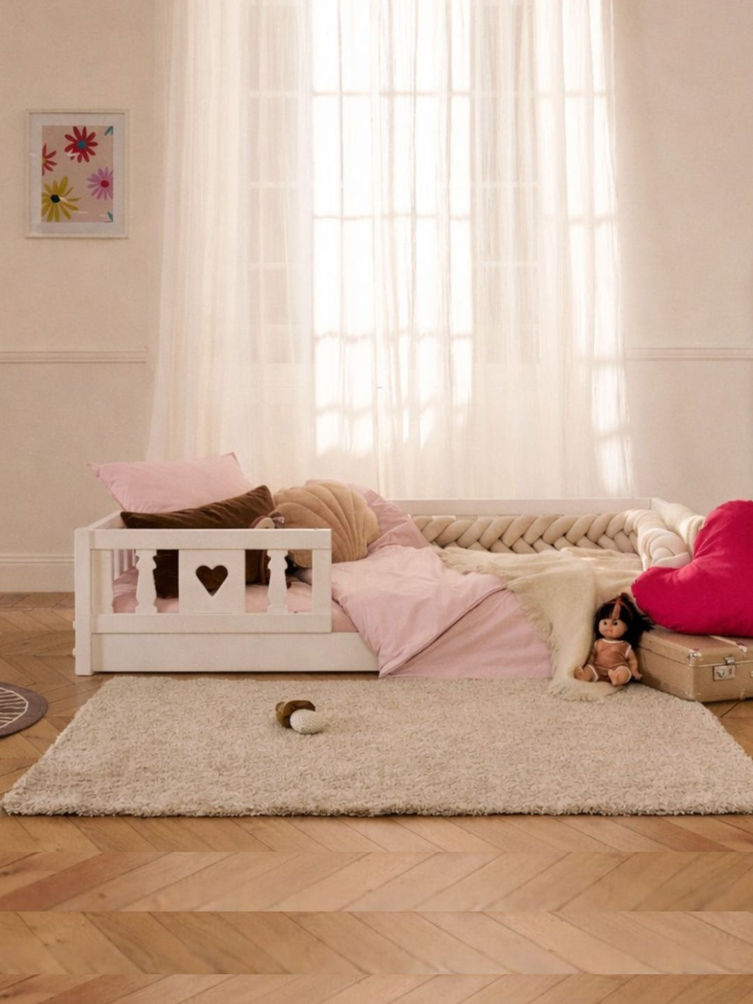 Vue d'ensemble du lit évolutif enfant Barcelone en bois peint en blanc avec barrière coeur dans chambre enfant.