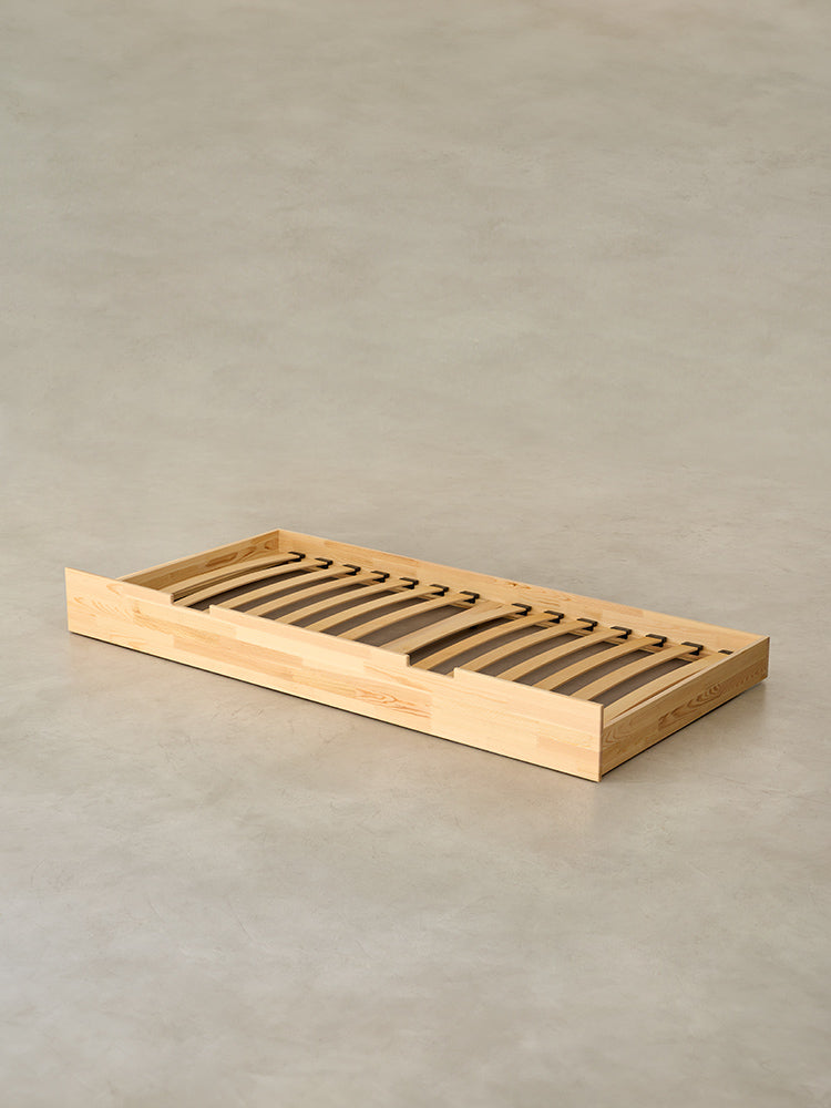 Children's cabin bed in natural wood with storage drawer, Montessori bed design.