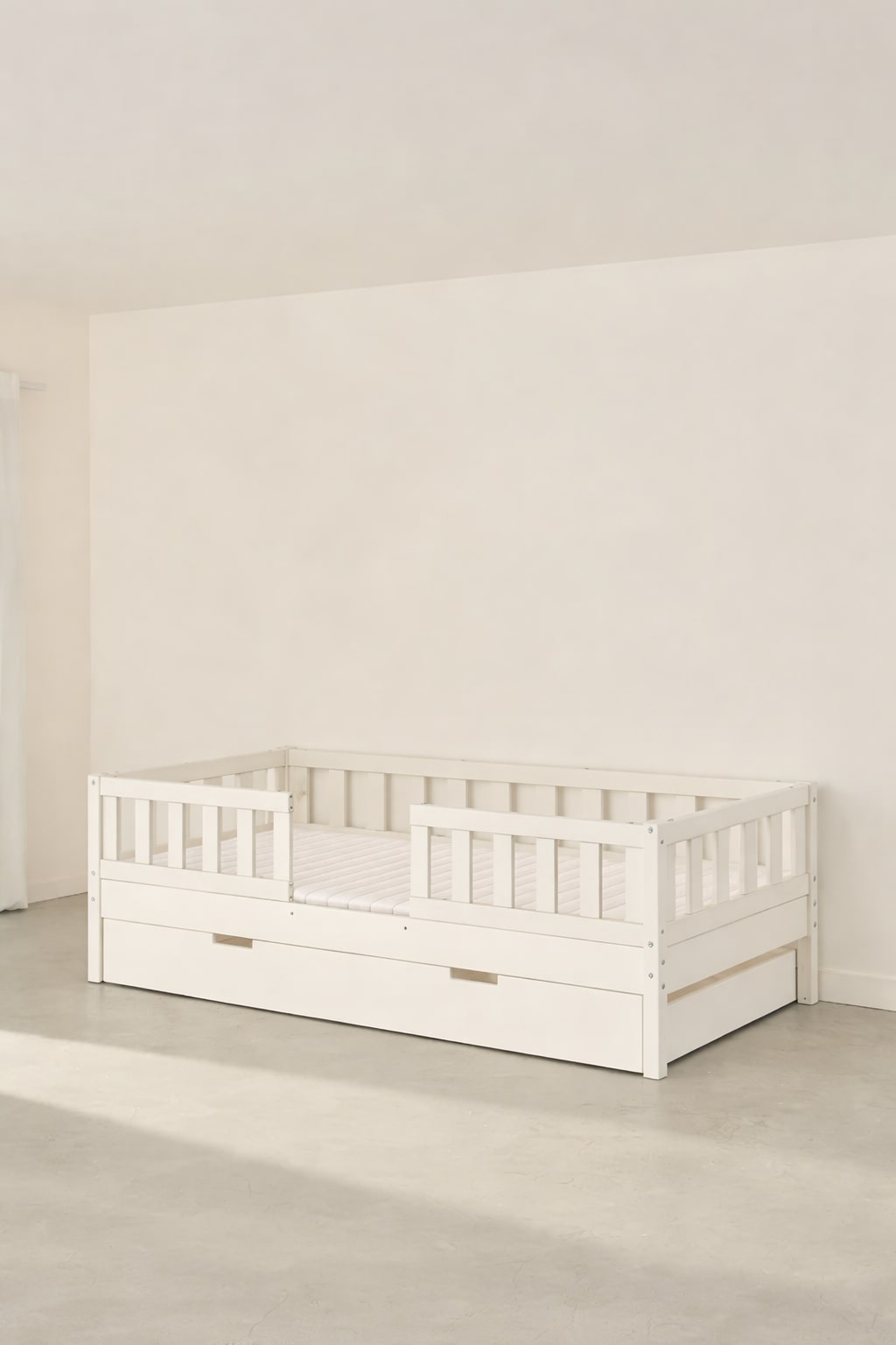 Barcelona white convertible children's bed with two barriers and built-in storage drawer.