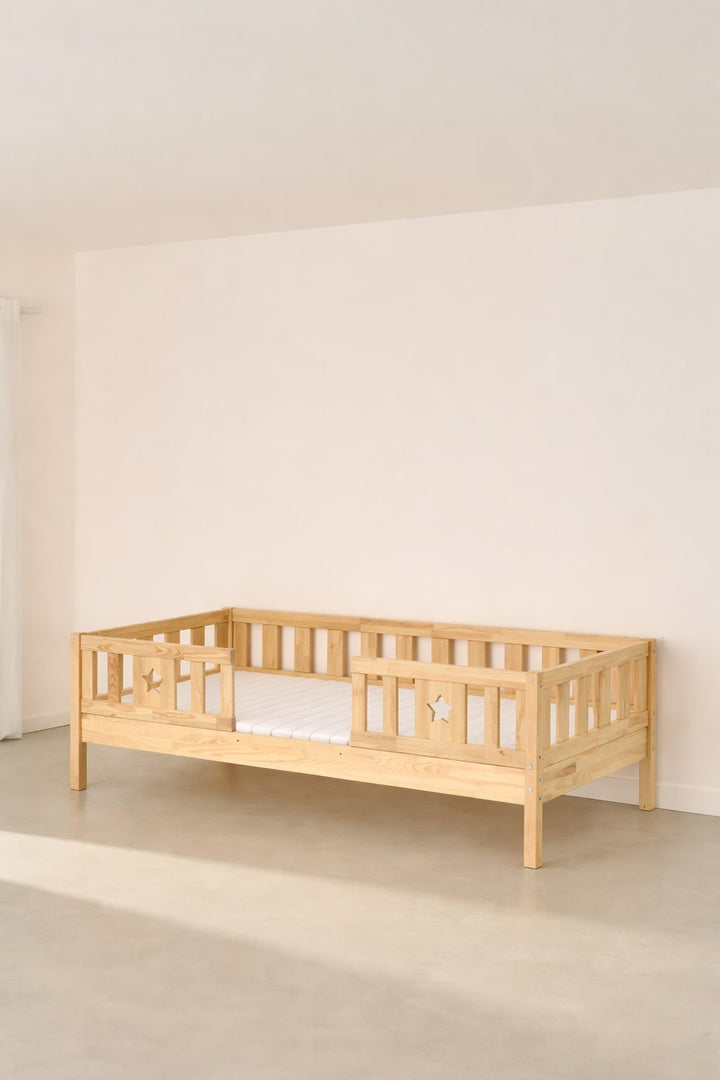 Barcelona convertible children's bed in natural wood with two star-shaped barriers, ideal for a modern nursery.