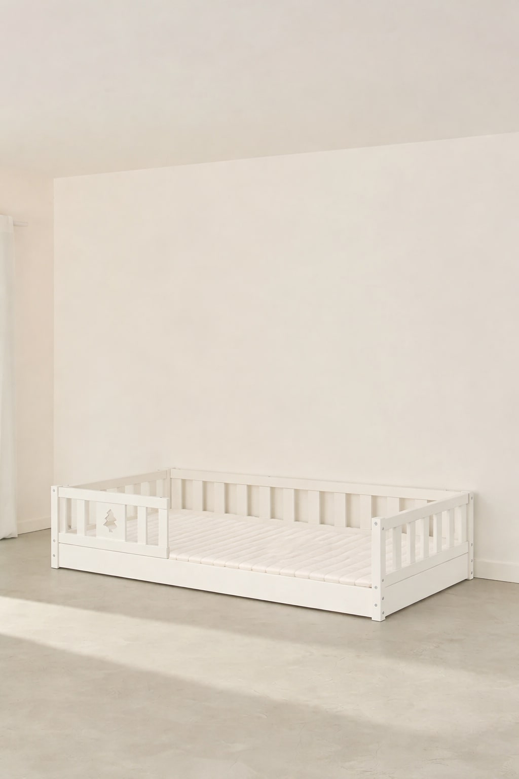 The Cabania Montessori-style convertible bed for children, close to the floor with its star-shaped guardrail.