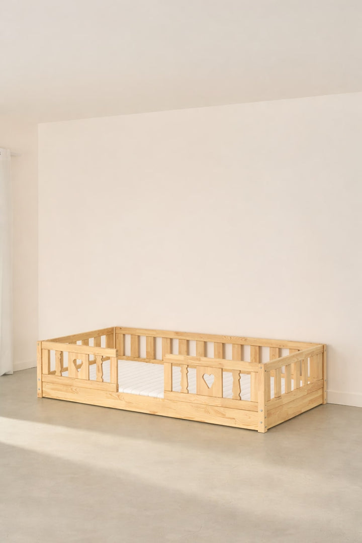 Barcelona natural wood Montessori convertible bed with two barriers and heart, ideal for a baby or child's bedroom.
